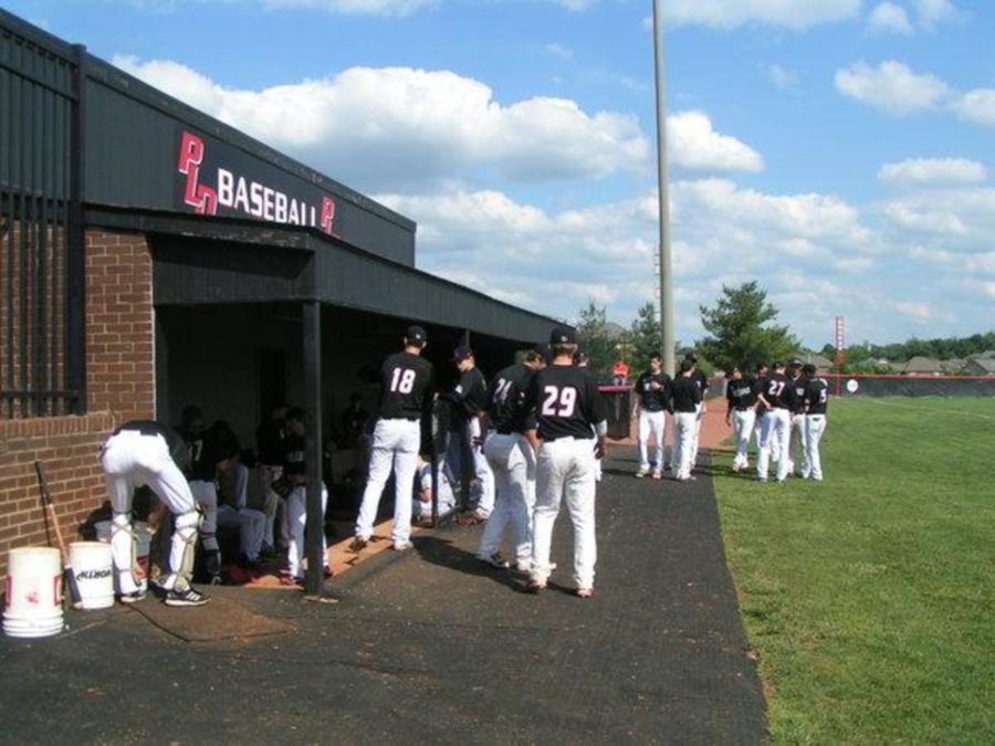 Dunbar baseball players near their dugout at the Dunbar Baseball Field