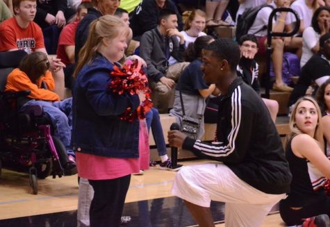 Mallory Burrows shows a heartfelt smile while Halkeiem Lewis is down on one knee during the pep rally promposal.