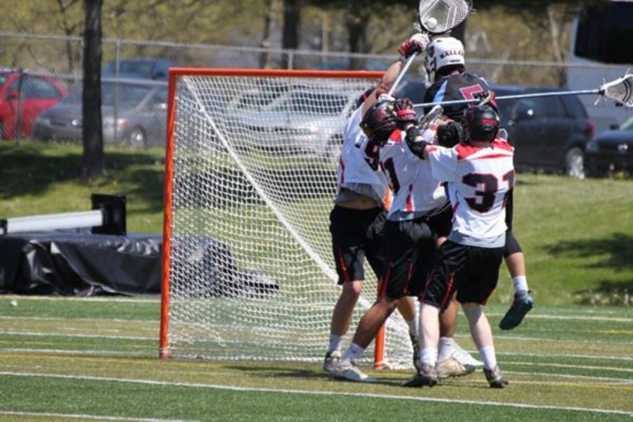 The PLD Lacrosse players jump on the goalie after the game. 