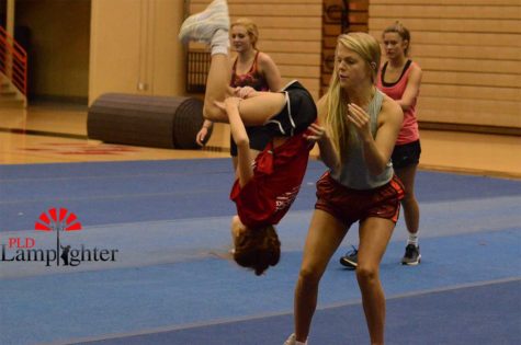 Senior Abby Rawls spots middle-schooler Hayden Woods on her back tuck