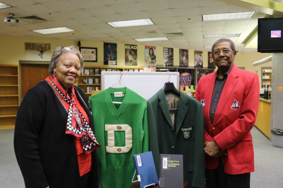 Mrs. Tava Clay and Mr. Julian Jackson Jr, alumni of the original Dunbar high school, pose next to their high school memorabilia. 
