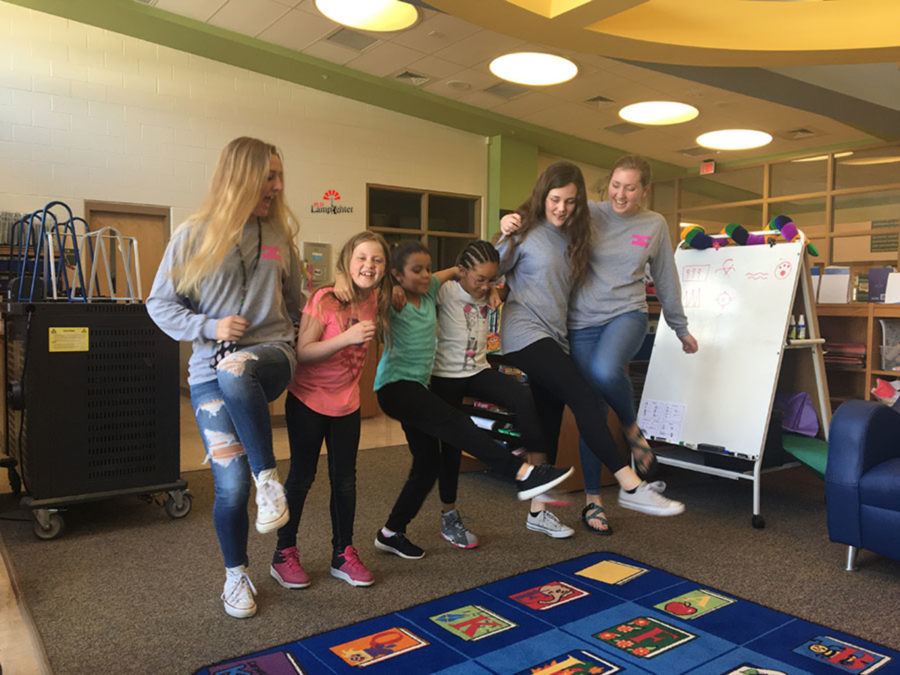Juniors Virginia Smith, Rachel Wagers, and Elizabeth Lippert dance with the girls at Arlington Elementary.
