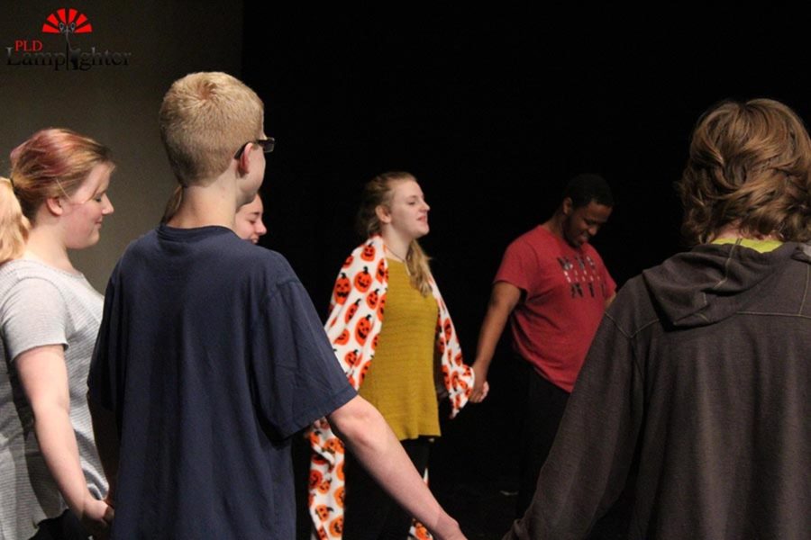 Students laugh as they prepare for an improv activity.