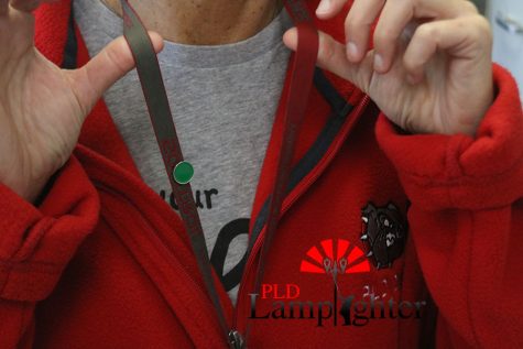 Math teacher Ms. Debra Reaguer shows off Dunbar's original teachers lanyards with a Green Dot pin.