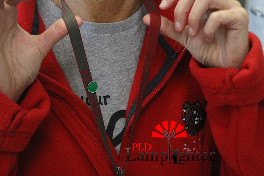 Math teacher Ms. Debra Reaguer shows off Dunbar's original teachers lanyards with a Green Dot pin.
