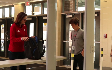 Principal Betsy Rains helps a student through the new metal detectors at PLD