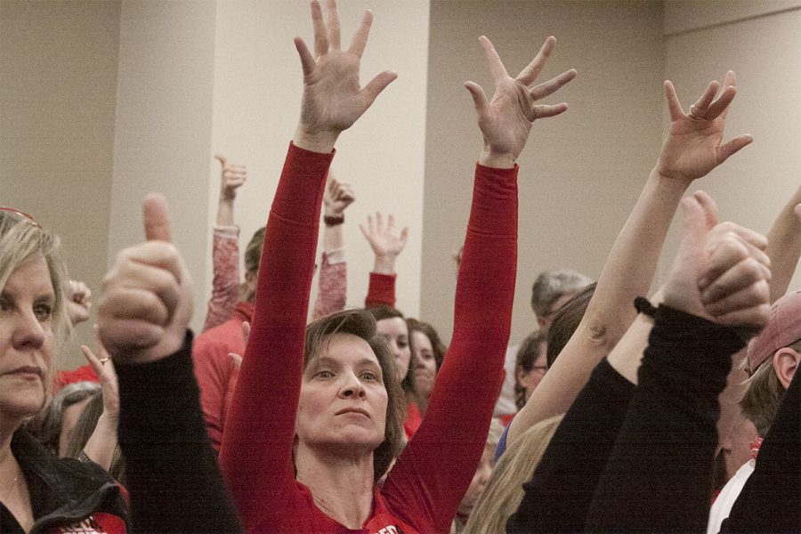 Teachers hold up jazz hands after being instructed to not make any noise.