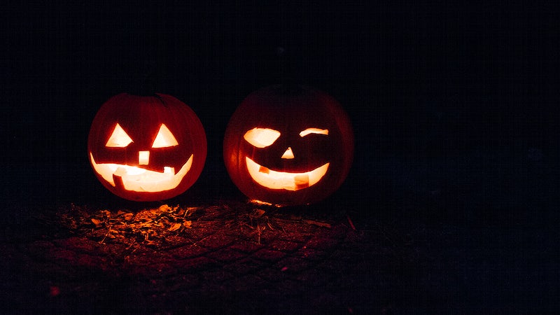 A pumpkin carved into a smiley face with shapes as the eyes and nose during Halloween as a lantern. Original public domain image from Wikimedia Commons