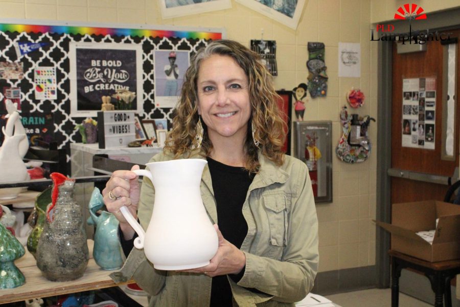 Ms. Eller holds up her finished design of the pitcher all the pottery classes are assigned to make. Her students use this pot as a reference for their sculpturing process. 