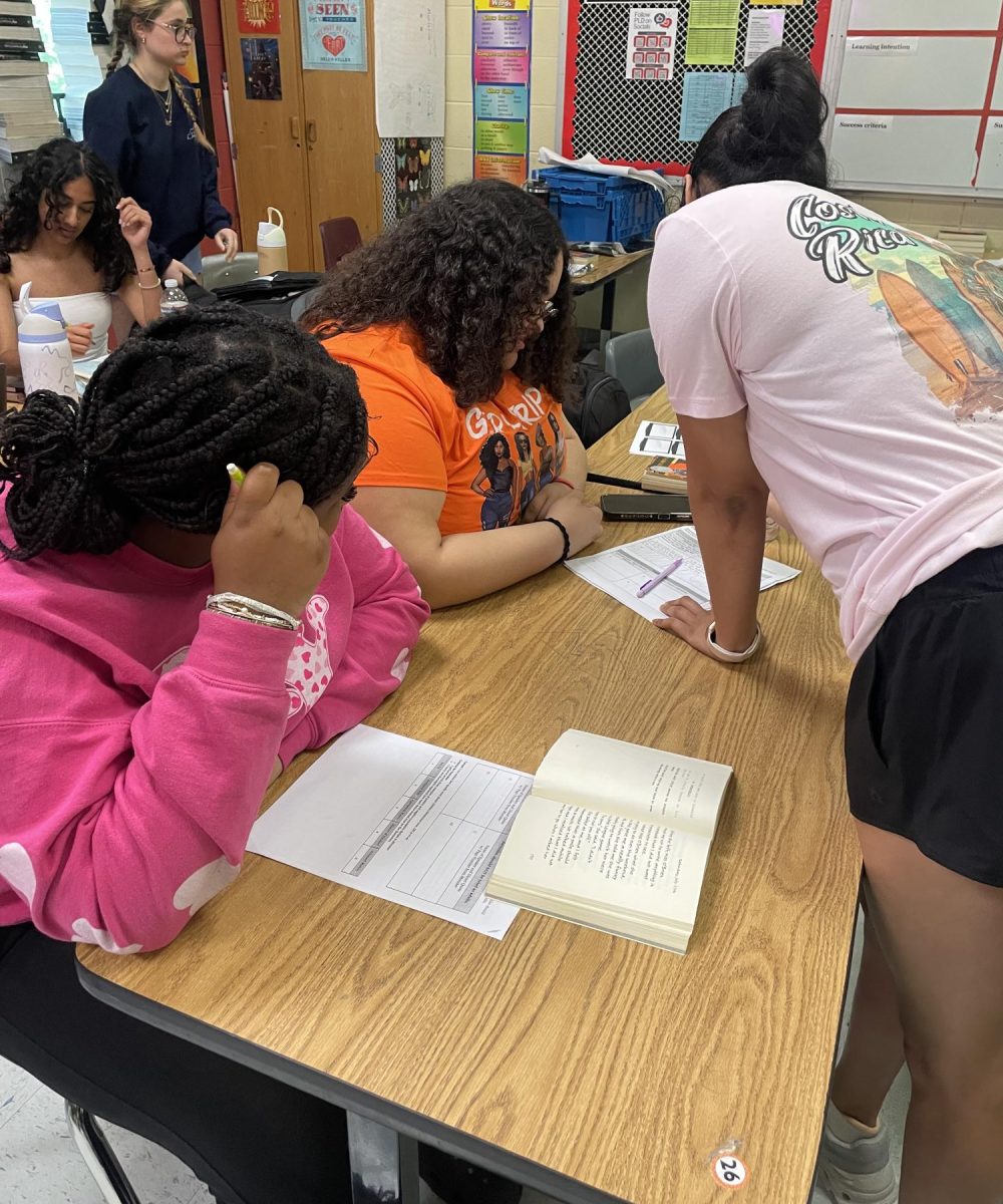 Senior Sukriti Kapoor assists Calleigh Snead and Daleigha Young in their freshman English class. The peer tutoring program at Dunbar allows peer to peer interaction and collaboration.